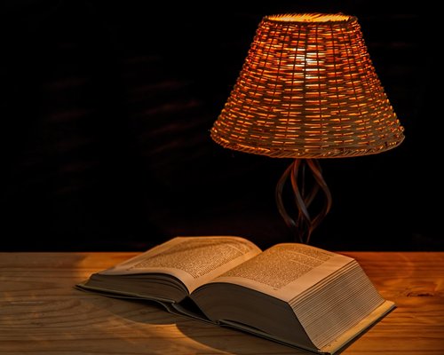 Cozy reading corner with warm ambient light and a focused reading lamp