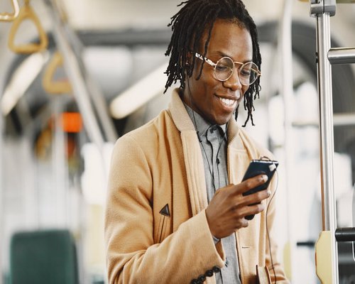 Person commuting on public transport while looking at their mobile phone comfortably